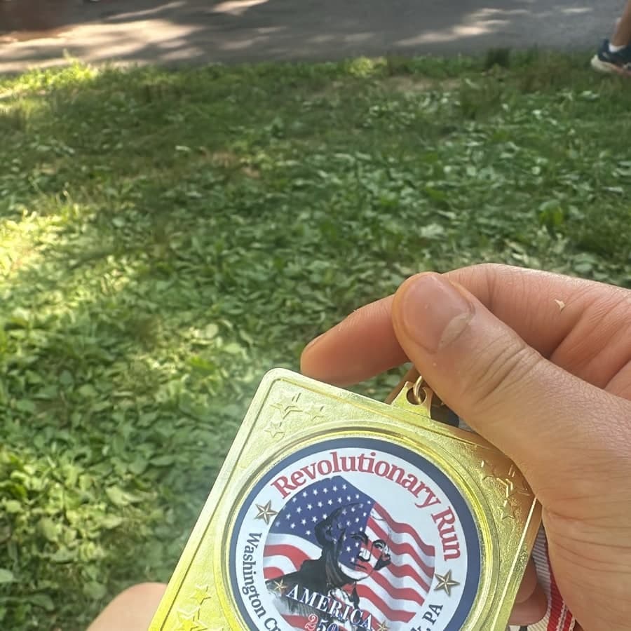 Holding a Revolutionary Run America 250 finisher medal